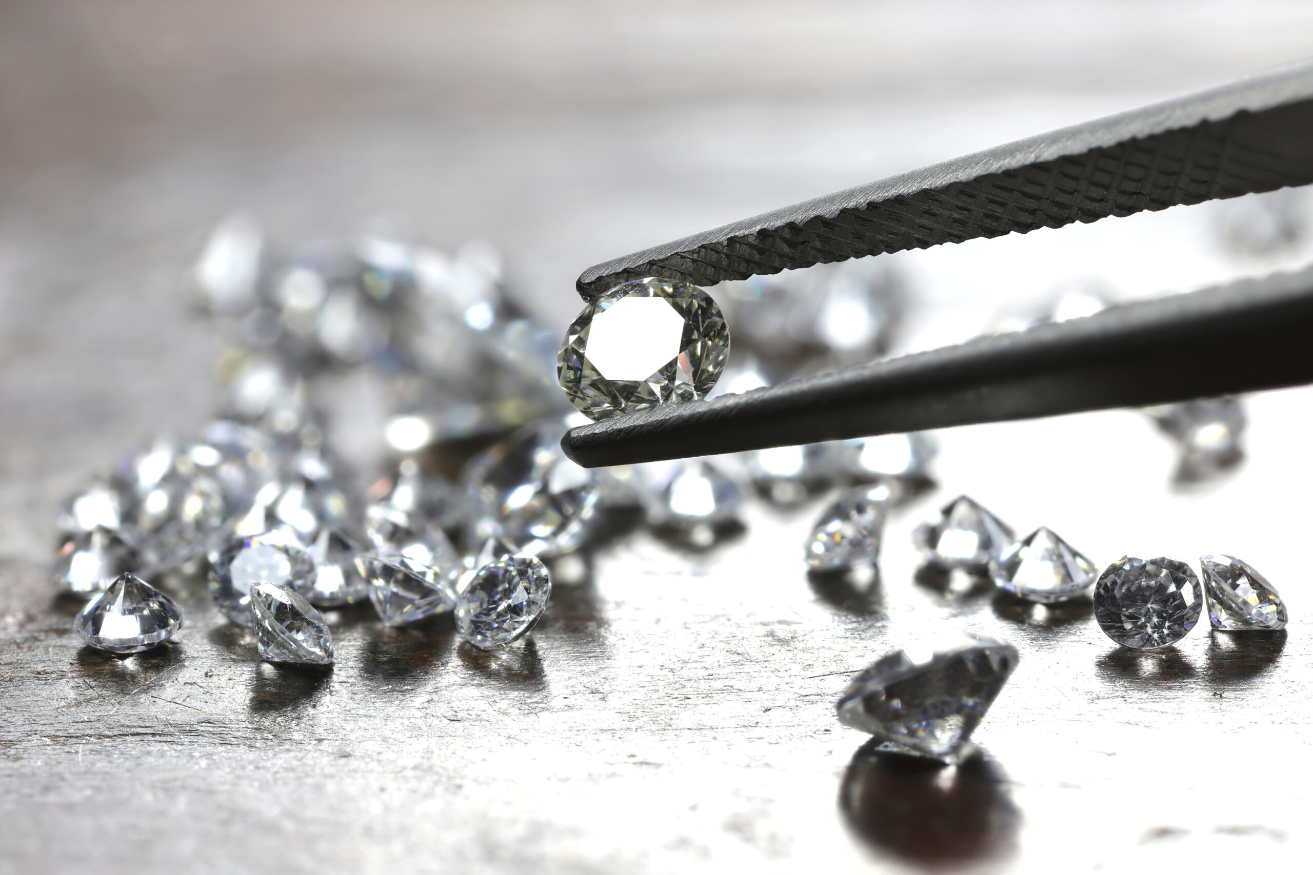 Brilliant cut diamond held by tweezers