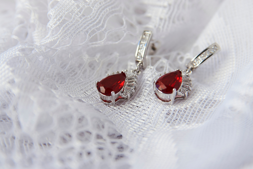 White gold pear-shaped earrings set with rubies surrounded by diamond haloes.