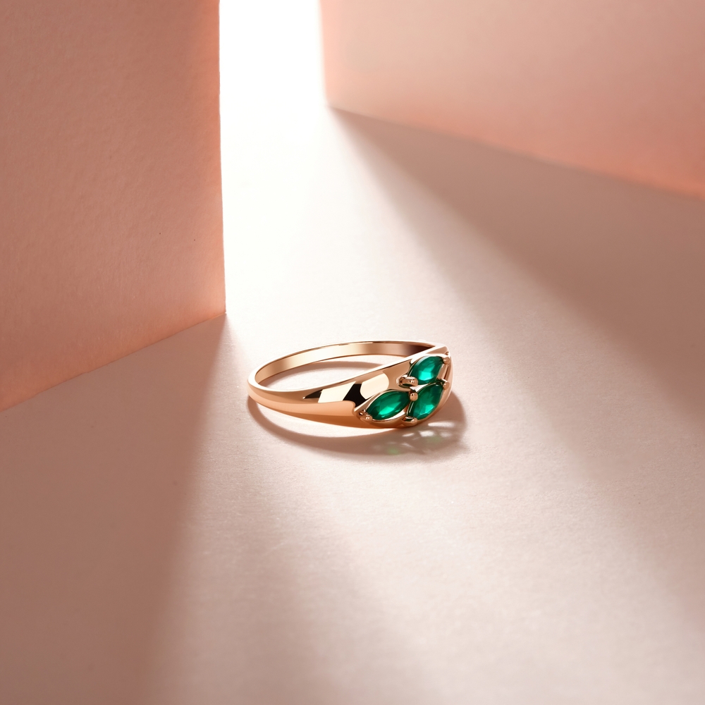 Yellow gold floral ring set with three emeralds.