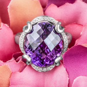 White gold cocktail ring centered with an amethyst and diamond halo.