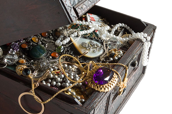 a chest full of vintage jewelry overflowing out of it.